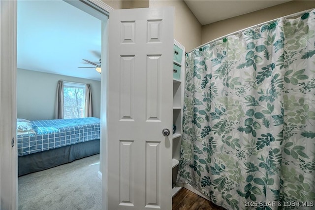 ensuite bathroom featuring ceiling fan, a shower with shower curtain, wood finished floors, and connected bathroom