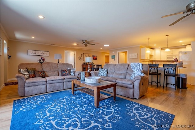 living area featuring a ceiling fan, crown molding, recessed lighting, and light wood-style floors