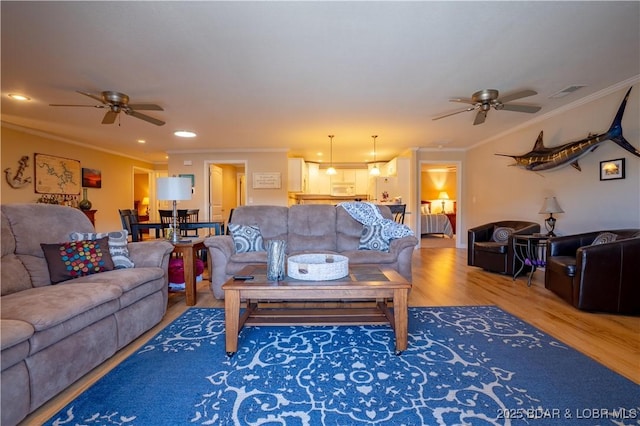 living room with visible vents, wood finished floors, recessed lighting, crown molding, and ceiling fan