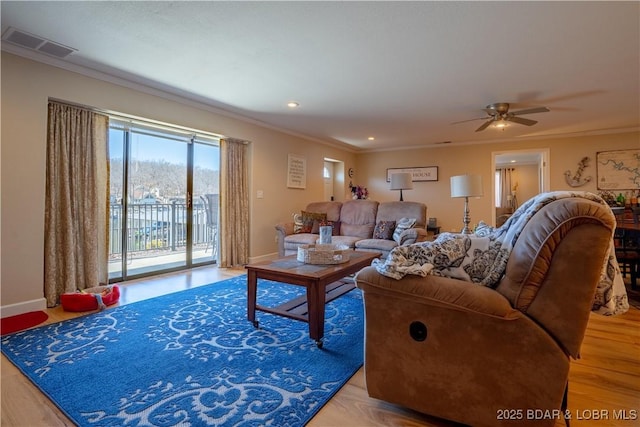 living room featuring baseboards, visible vents, and ornamental molding