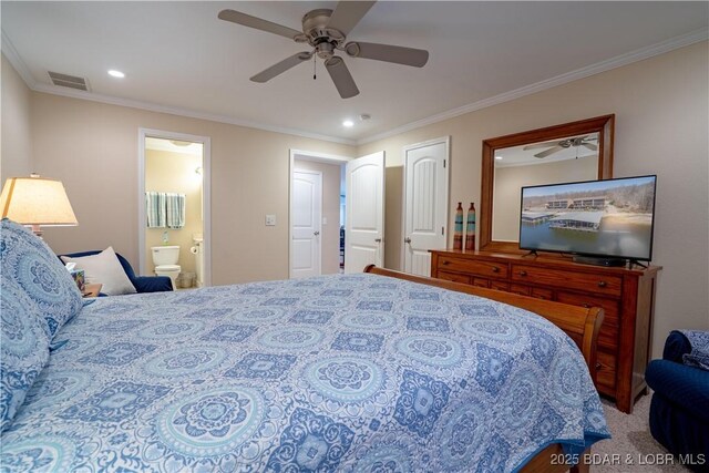 carpeted bedroom with a ceiling fan, visible vents, ensuite bathroom, and ornamental molding