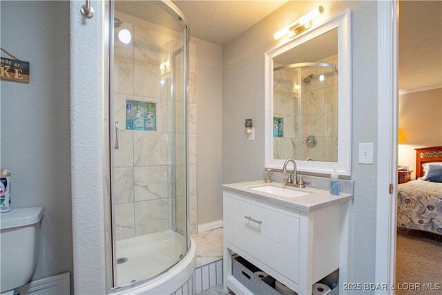 ensuite bathroom featuring a shower stall, ensuite bath, vanity, and toilet