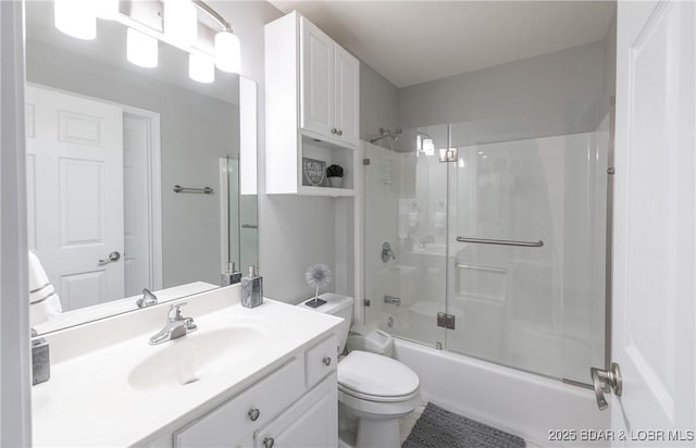 bathroom featuring bath / shower combo with glass door, toilet, and vanity