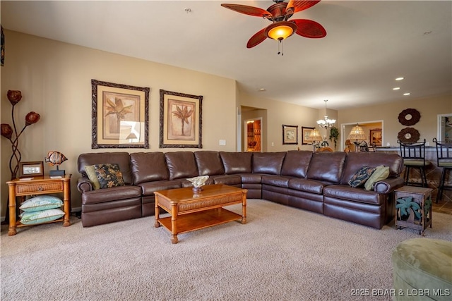 carpeted living room featuring recessed lighting and ceiling fan with notable chandelier