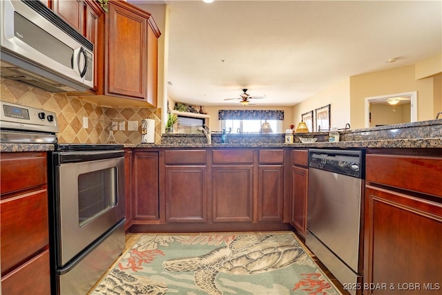 kitchen with a sink, stainless steel appliances, tasteful backsplash, and ceiling fan