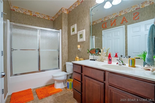 full bath with tile patterned flooring, wallpapered walls, toilet, combined bath / shower with glass door, and vanity