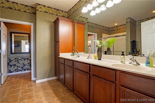 full bathroom featuring wallpapered walls, a shower stall, double vanity, and a sink