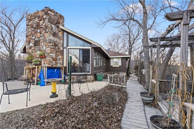 back of house featuring a chimney