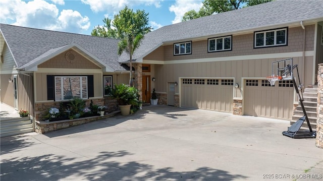 view of front of house featuring stone siding, concrete driveway, a garage, and a shingled roof