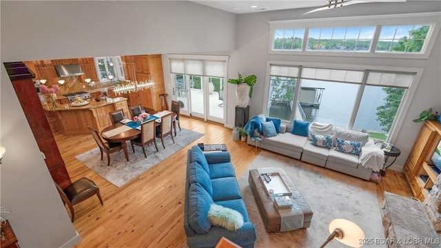 living area with light wood-style flooring and a towering ceiling