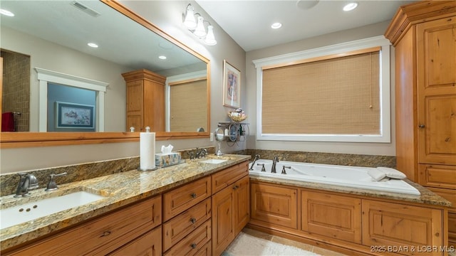 full bath featuring a garden tub, recessed lighting, visible vents, and a sink