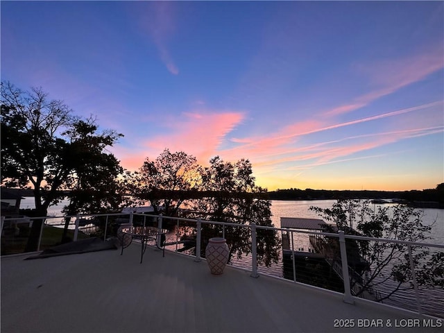 patio terrace at dusk with a balcony and a water view