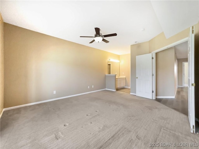 unfurnished bedroom featuring carpet flooring, connected bathroom, baseboards, and ceiling fan