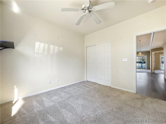 unfurnished bedroom with a closet, baseboards, carpet, and a ceiling fan