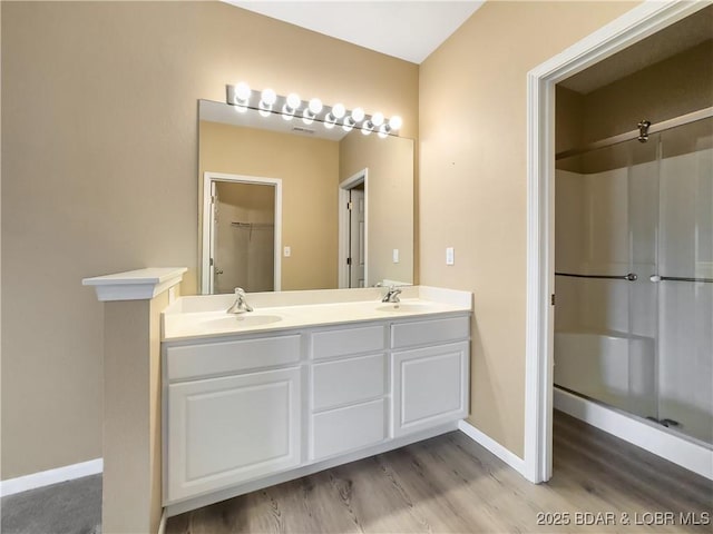 full bathroom featuring a shower stall, baseboards, and a sink