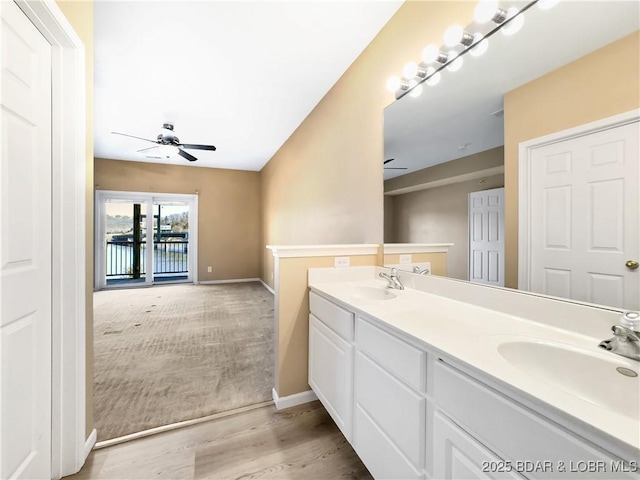 full bath featuring double vanity, a ceiling fan, and a sink