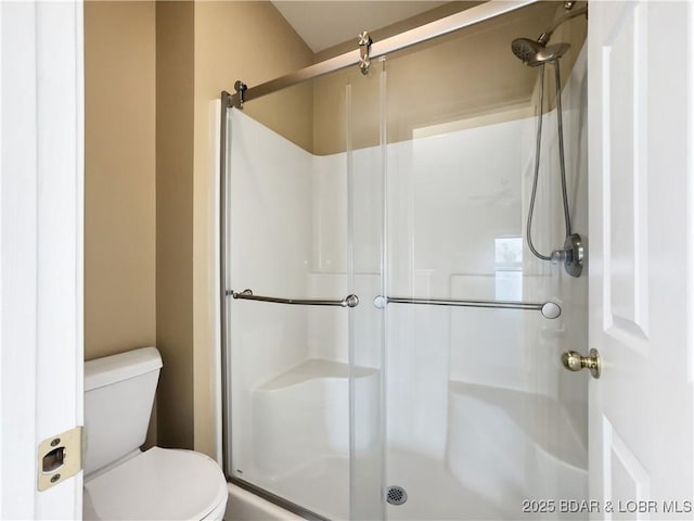 bathroom with a shower stall and toilet