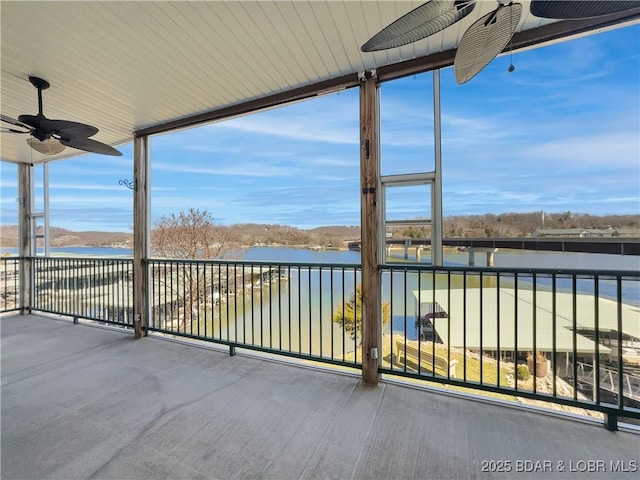 unfurnished sunroom with a water view, plenty of natural light, and ceiling fan