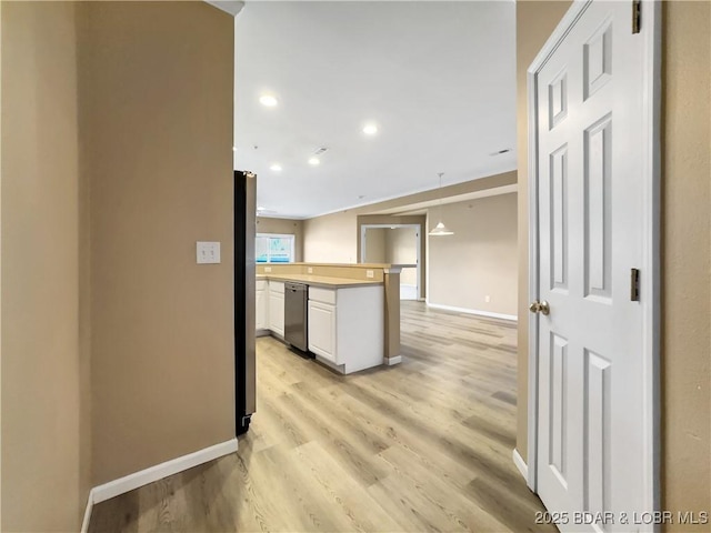 kitchen with baseboards, light wood finished floors, freestanding refrigerator, light countertops, and white cabinetry