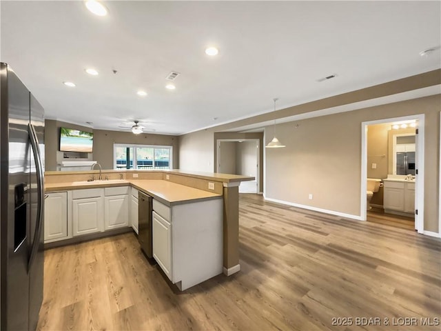 kitchen featuring appliances with stainless steel finishes, ceiling fan, light countertops, and light wood finished floors