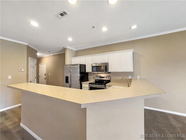 kitchen with visible vents, a peninsula, a sink, light countertops, and appliances with stainless steel finishes