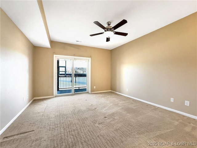 carpeted spare room featuring visible vents, baseboards, and a ceiling fan