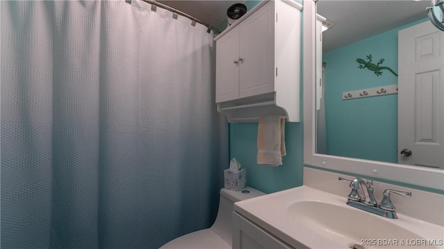 bathroom with a shower with shower curtain, toilet, and vanity