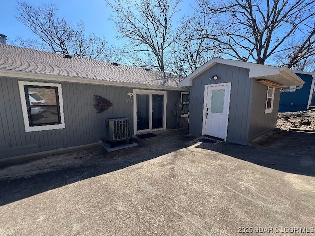 back of house with an outbuilding, central AC unit, and a patio