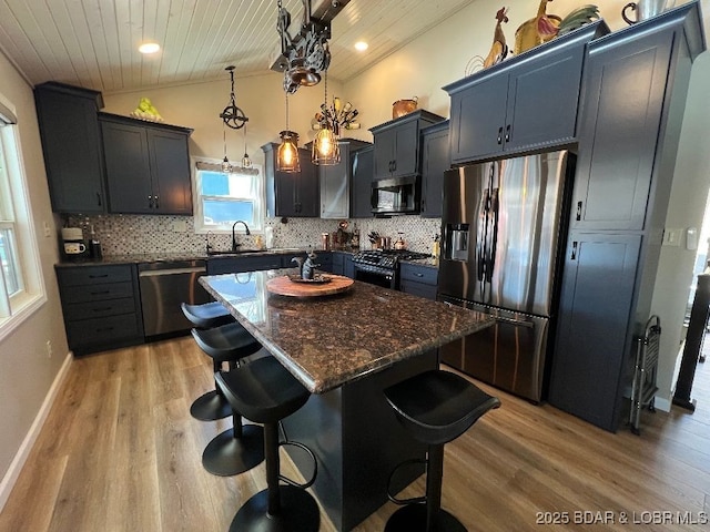 kitchen with wood ceiling, appliances with stainless steel finishes, a breakfast bar, and lofted ceiling