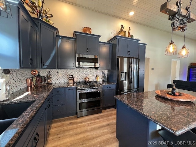 kitchen with tasteful backsplash, dark stone countertops, appliances with stainless steel finishes, light wood-style flooring, and wooden ceiling