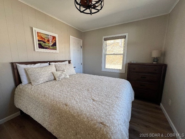 bedroom with baseboards, dark wood-style flooring, and ornamental molding