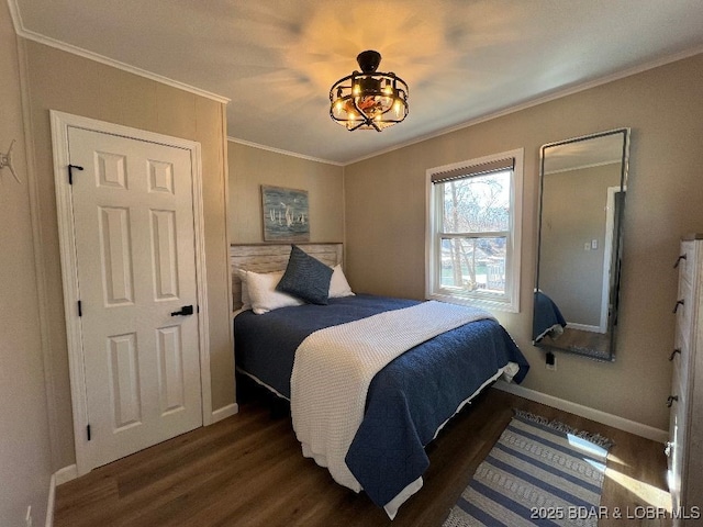 bedroom with wood finished floors, baseboards, and ornamental molding