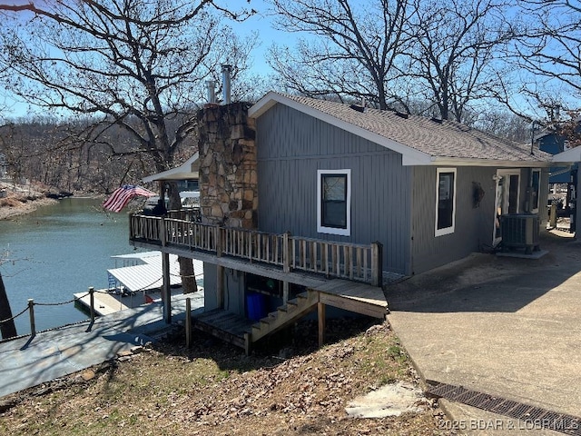 view of home's exterior featuring stairs and a deck with water view