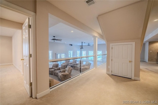 hall with visible vents, light carpet, and baseboards