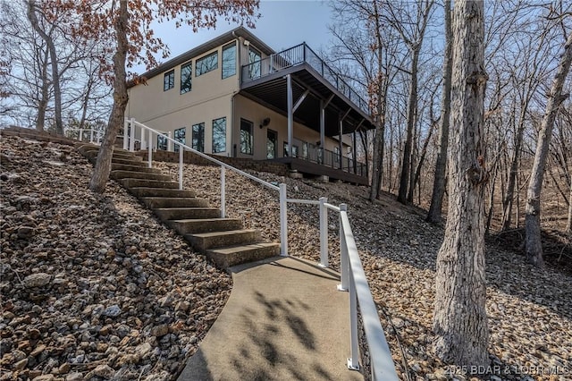 back of property featuring stairway and stucco siding