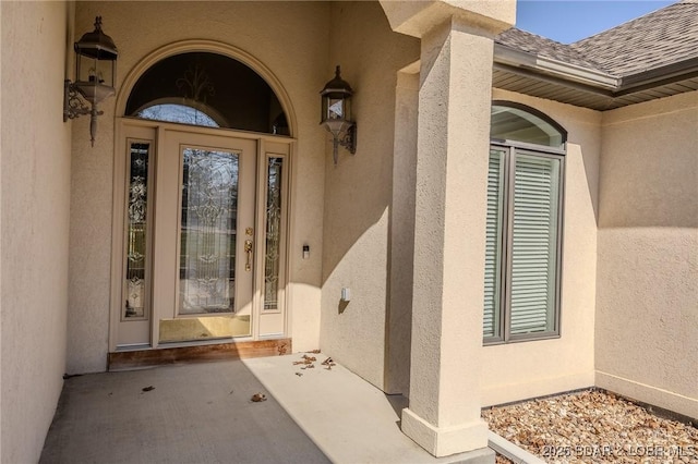 view of exterior entry featuring stucco siding