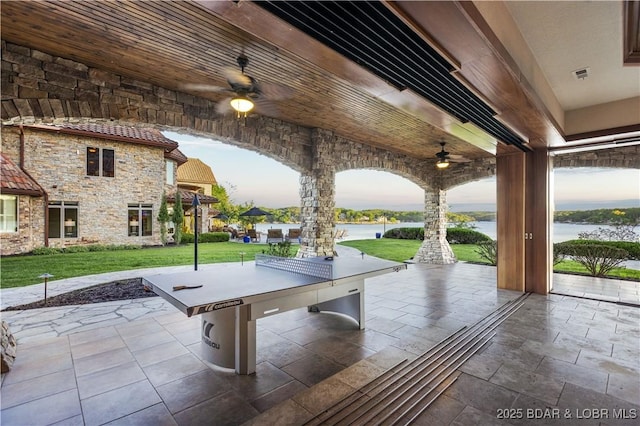 view of patio / terrace with a ceiling fan, visible vents, a water view, and area for grilling
