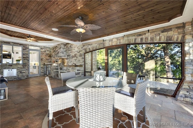 dining area featuring a ceiling fan, a tray ceiling, and wooden ceiling