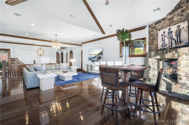 dining area with visible vents, wood-type flooring, an inviting chandelier, and crown molding