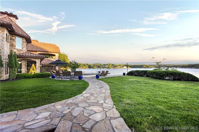 view of yard with a patio area and a water view