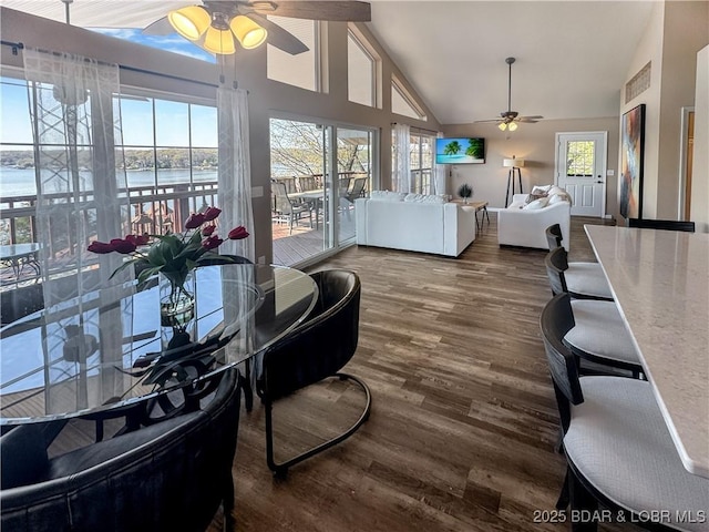 interior space featuring ceiling fan, wood finished floors, and high vaulted ceiling
