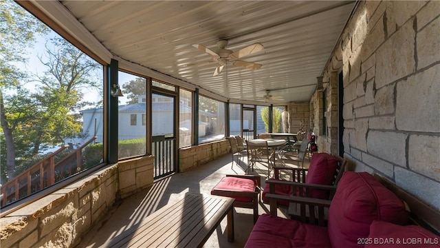 unfurnished sunroom featuring a ceiling fan