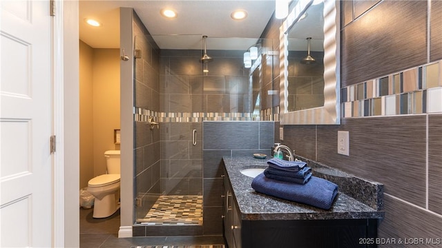 full bathroom featuring toilet, recessed lighting, a stall shower, tile patterned floors, and vanity