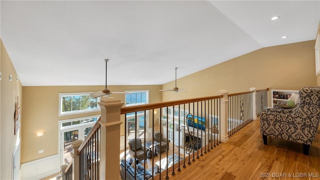 corridor featuring vaulted ceiling, recessed lighting, wood finished floors, and an upstairs landing