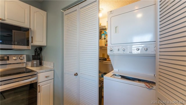 washroom featuring laundry area and stacked washer / dryer