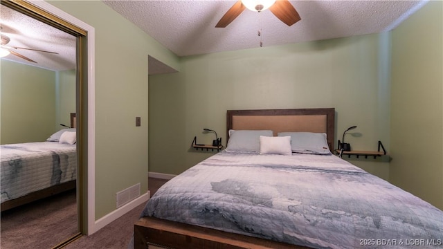 bedroom with visible vents, a textured ceiling, ceiling fan, and carpet flooring