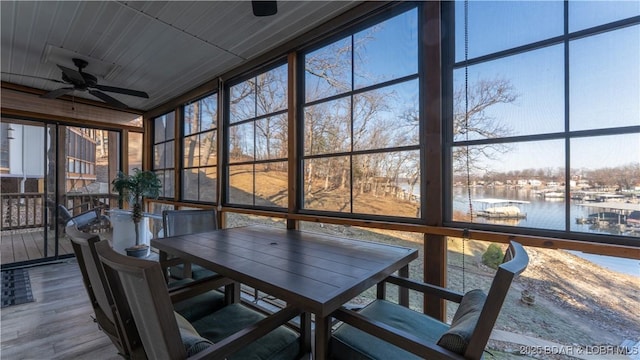 sunroom / solarium with a water view and ceiling fan