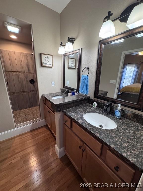 bathroom featuring vanity, a shower stall, and hardwood / wood-style flooring