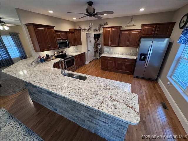 217 Highline Rd, Lake Ozark, MO 65049 - kitchen with ceiling fan, visible vents, a sink, a peninsula, and stainless steel appliances
