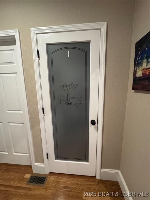 room details featuring wood finished floors, visible vents, and baseboards